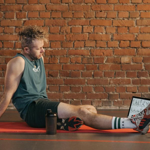 Person meditating peacefully after a workout session with a smile.